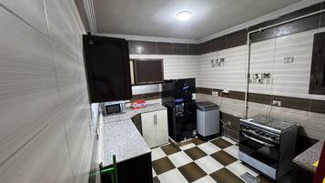 A compact kitchen with a microwave, refrigerator, and stove.