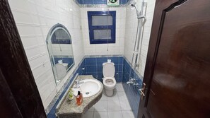A bathroom with a toilet, sink, and shower. - Hotel apartment view pyramids (Giza Governorate)
