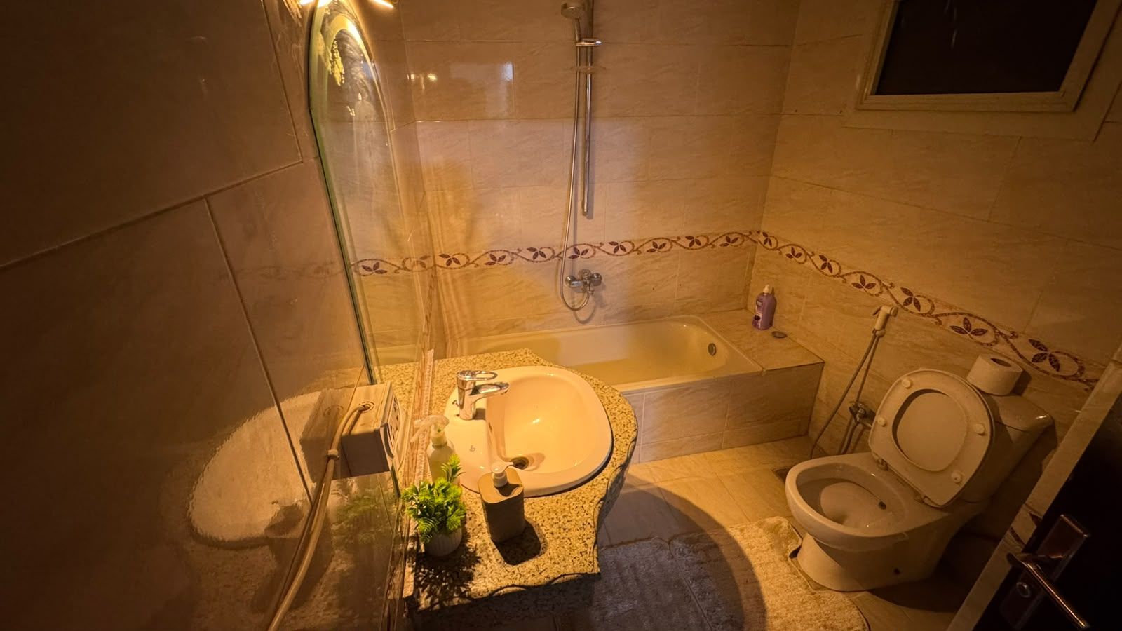 A bathroom with a sink, toilet, and shower.
