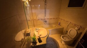 A bathroom with a sink, toilet, and shower. - Hotel apartment view pyramids (Giza Governorate)