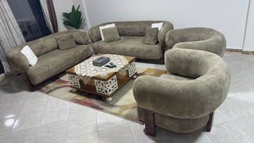 A living room with a sectional sofa, a round coffee table, and a single armchair.