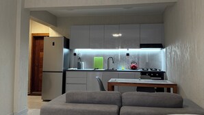 A compact living space with a kitchenette, a sofa, and a dining table. - Monte Cara (Mindelo)