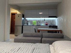 A compact living space with a kitchenette, a sofa, and a dining table. - Monte Cara (Mindelo)