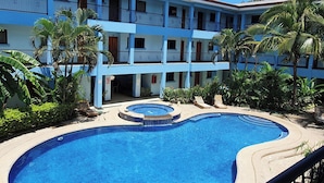 A hotel with a swimming pool, multiple balconies, and tropical vegetation. - Marina Loft Condos # 101, 1 Floor (Sardinal)