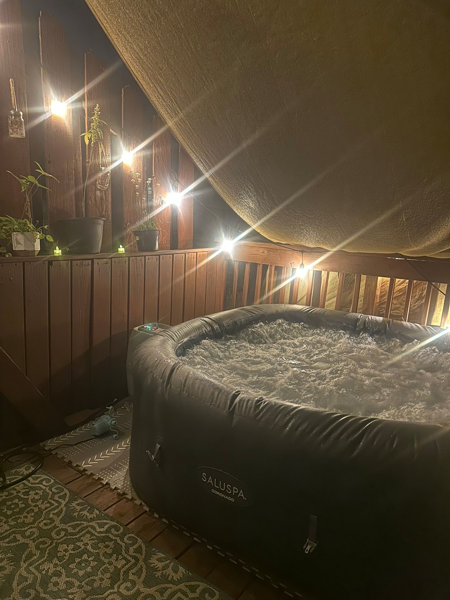 Un jacuzzi debajo de una terraza de madera con vistas al cielo.