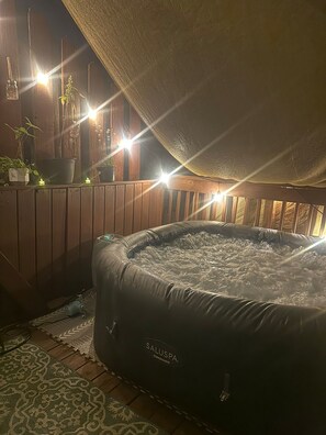 A hot tub under a wooden deck with a view of the sky. - Serene 2-bedroom apartment with concierge in vibrant St. Louis (St. Louis)