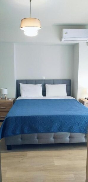 Ein Schlafzimmer mit einem Bett, einem Nachttisch, einer Lampe und einer Pendelleuchte.