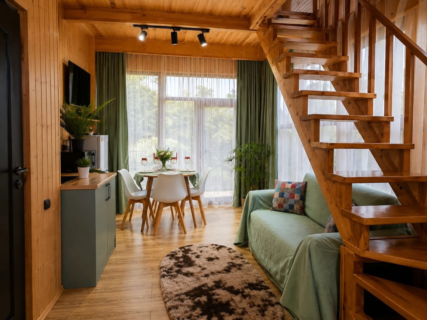 A wooden interior with a staircase, a dining area with a table and chairs, and a sofa.