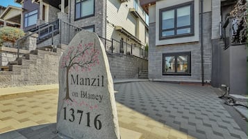A stone marker with a tree and text indicating 'Manzil on Blaney 13716.'