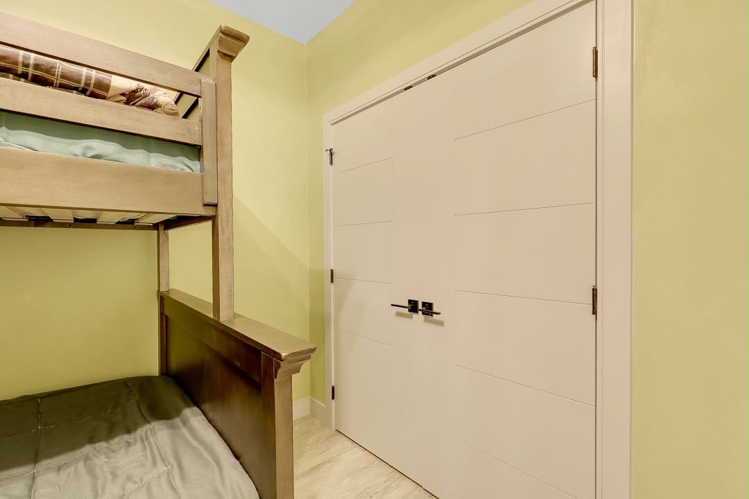Ein Zimmer mit einem Etagenbett, einem Kleiderschrank und einer Tür.