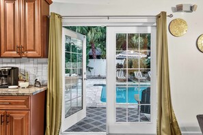 A kitchen with wooden cabinets, a coffee machine, and a sign that says 'Coffee.' - Heated Pool + Game Room, Near Clearwater Beach (Largo)