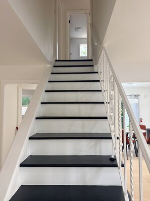 A staircase with white walls and black steps leading to a door. - NEW LISTING! Escape to the Cape Beach Retreat (Cape May)