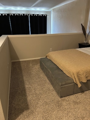 A bedroom with a bed, a window with curtains, a nightstand, and a decorative vase. - Cozy 1-bedroom apartment in brilliant Houston with AC (Houston)