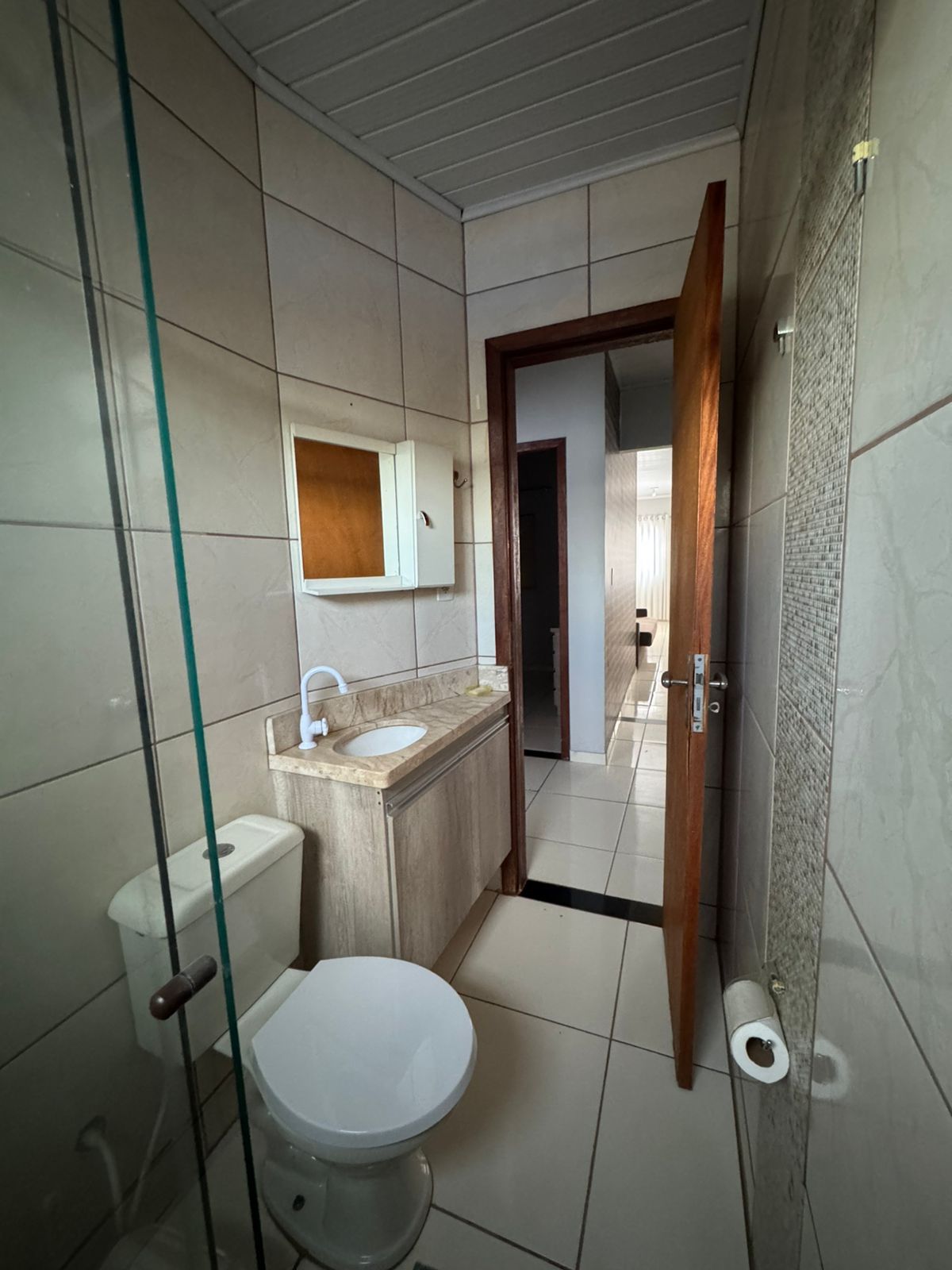 Une petite salle de bain comprenant des toilettes, un lavabo et un miroir.