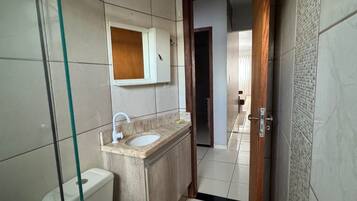 Ein kleines Badezimmer mit Toilette, Waschbecken und Spiegel.