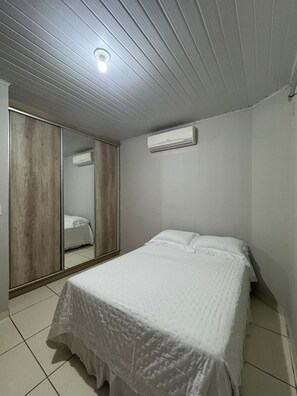 Ein Schlafzimmer mit einem Bett, einem Kleiderschrank und einer Klimaanlage.