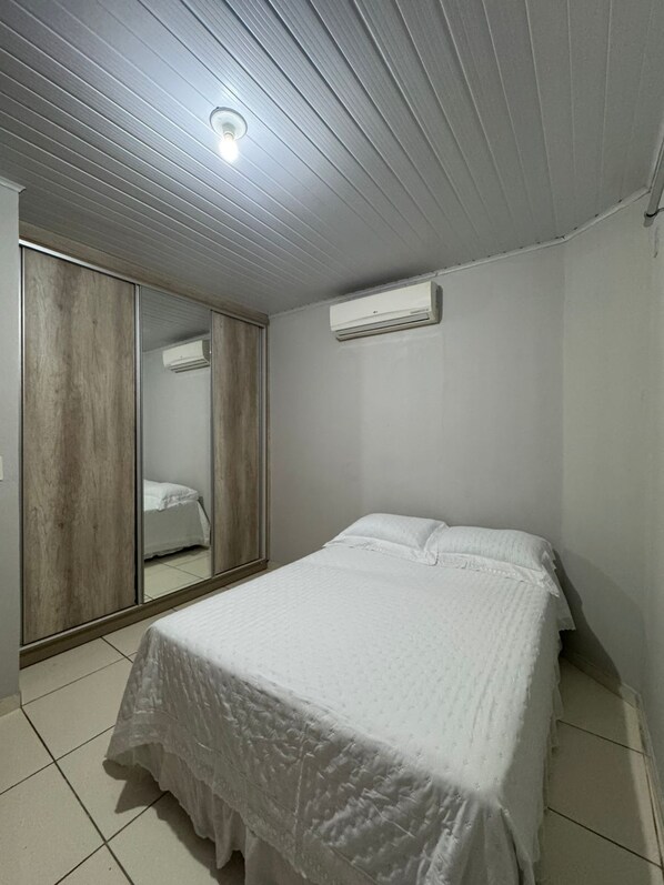 Ein Schlafzimmer mit einem Bett, einem Kleiderschrank und einer Klimaanlage.