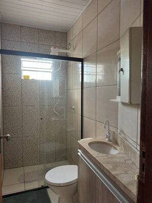 Ein Badezimmer mit Dusche, Toilette und Waschbecken.