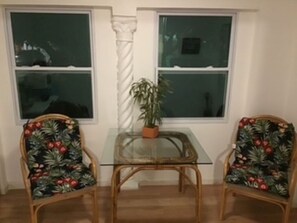 A room with two wicker chairs with floral upholstery, a glass-top table, and a potted plant. - Cozy 1-bedroom Casita in the heart of Miami (Miami)
