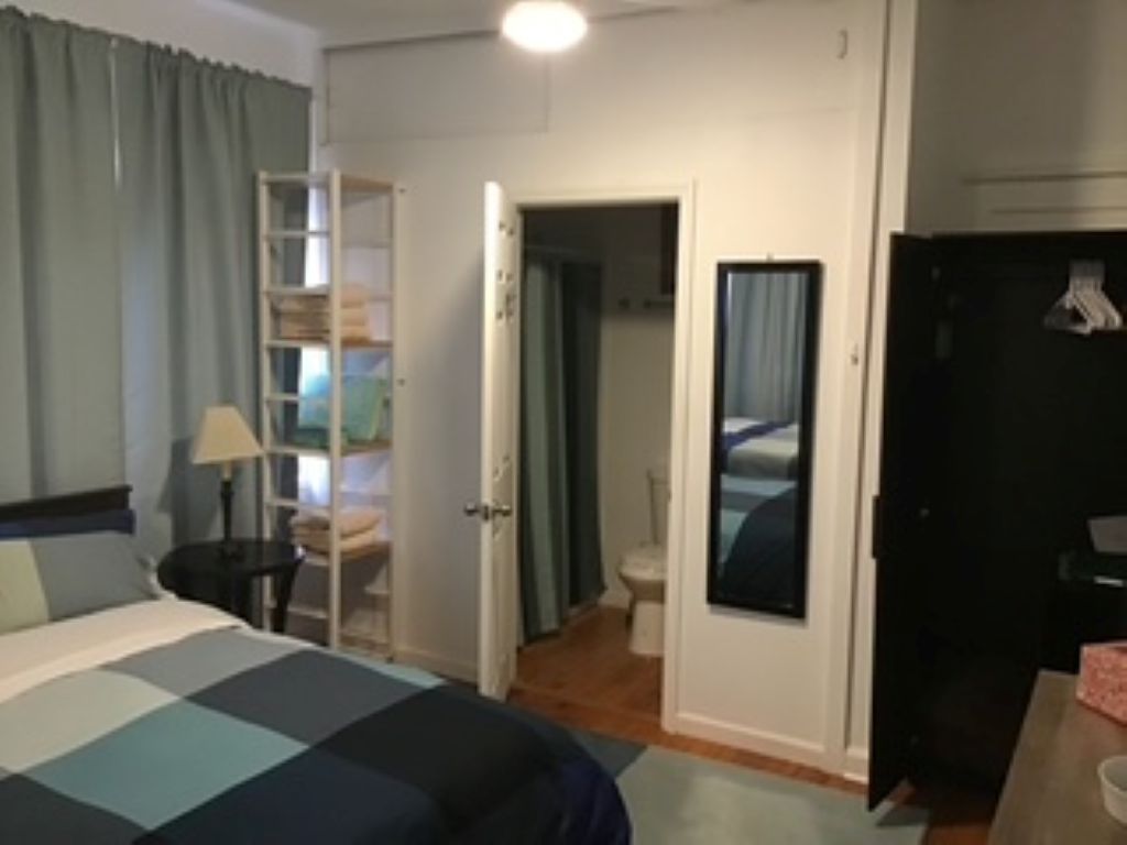 Habitación de hotel con cama, escritorio, armario y baño.