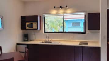 A kitchen with a window, a microwave, and a ceiling fan.