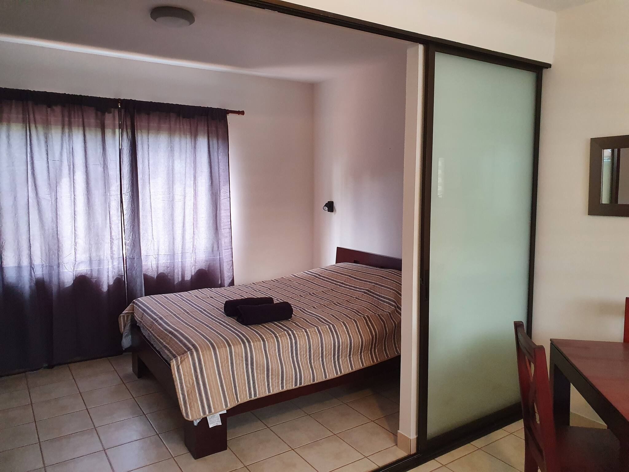 Une pièce comprenant un lit, un bureau et une porte coulissante.