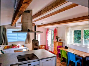 A compact kitchen with a central island, a built-in oven, and a chimney.