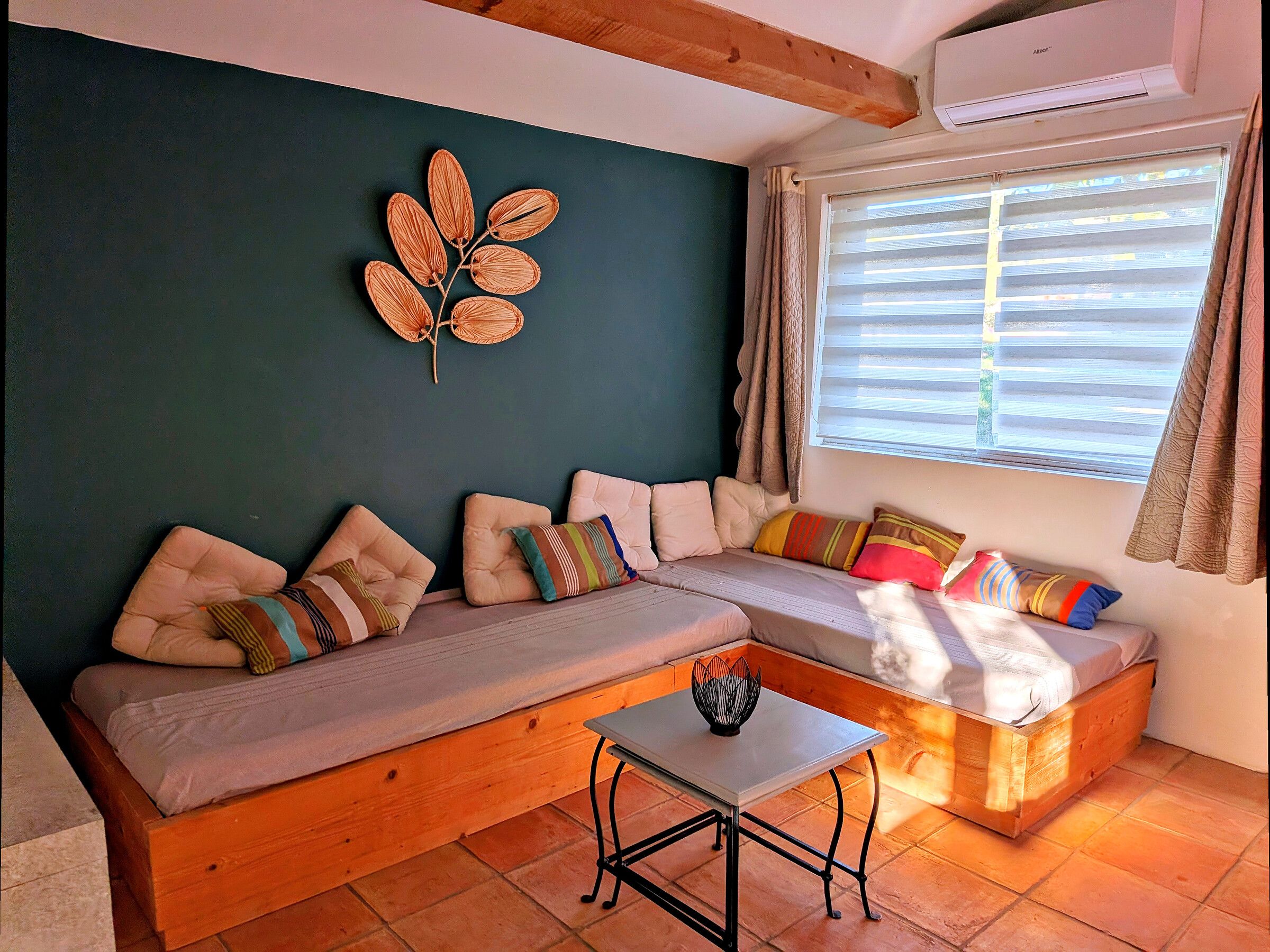 Una sala de estar acogedora con un sofá seccional, una mesita y un adorno de pared.