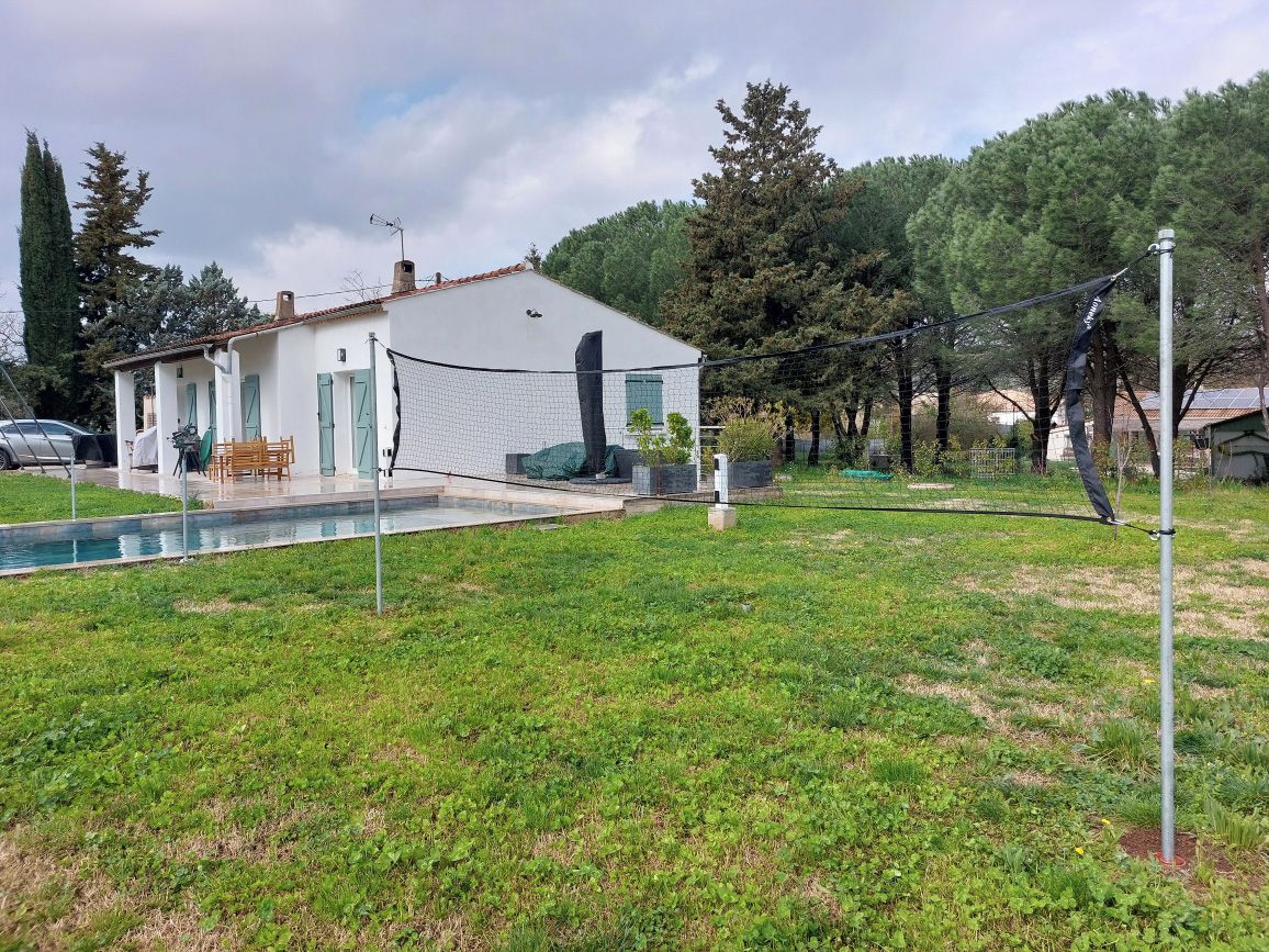 Une maison avec une piscine, un court de tennis et une cour clôturée.
