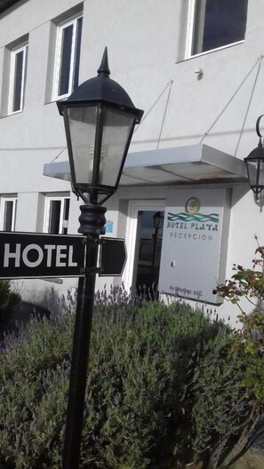 A hotel sign with a reception banner, a street lamp, and a building facade.