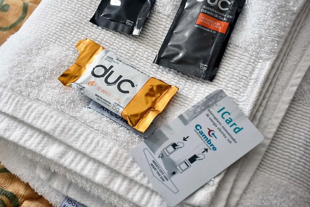 Toalha com um cartão dobrado Icard e dois sachês de chá DUC.