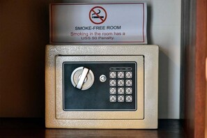 A smoke-free room sign with a penalty notice and a combination lock safe.