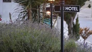 Un banco, una señal de calle y un poste de luz con un letrero que dice 'HOTEL'.