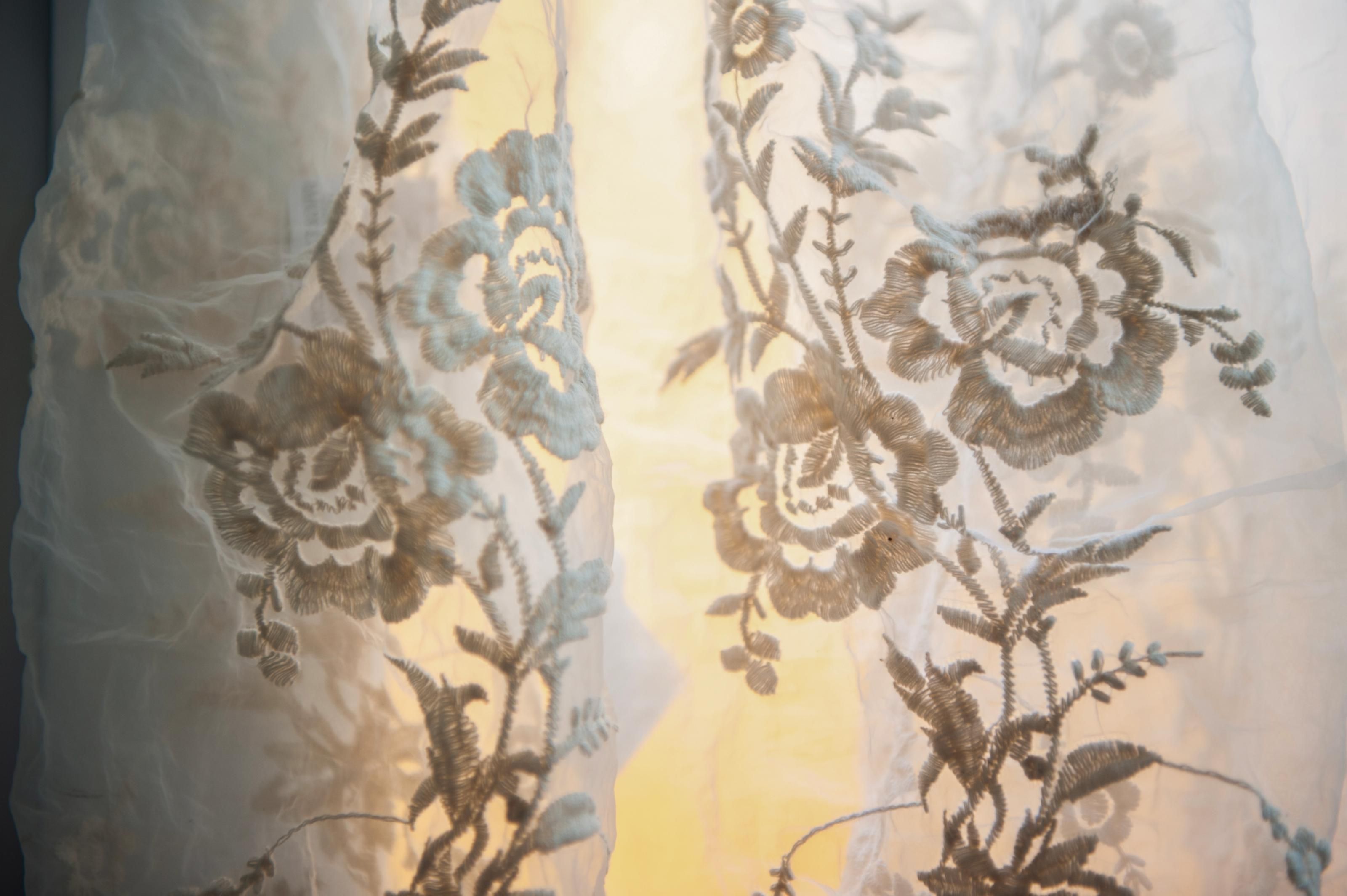 Un rideau léger en voile, orné de broderies florales.