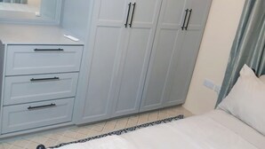 Quarto com cama, guarda-roupa e cômoda.