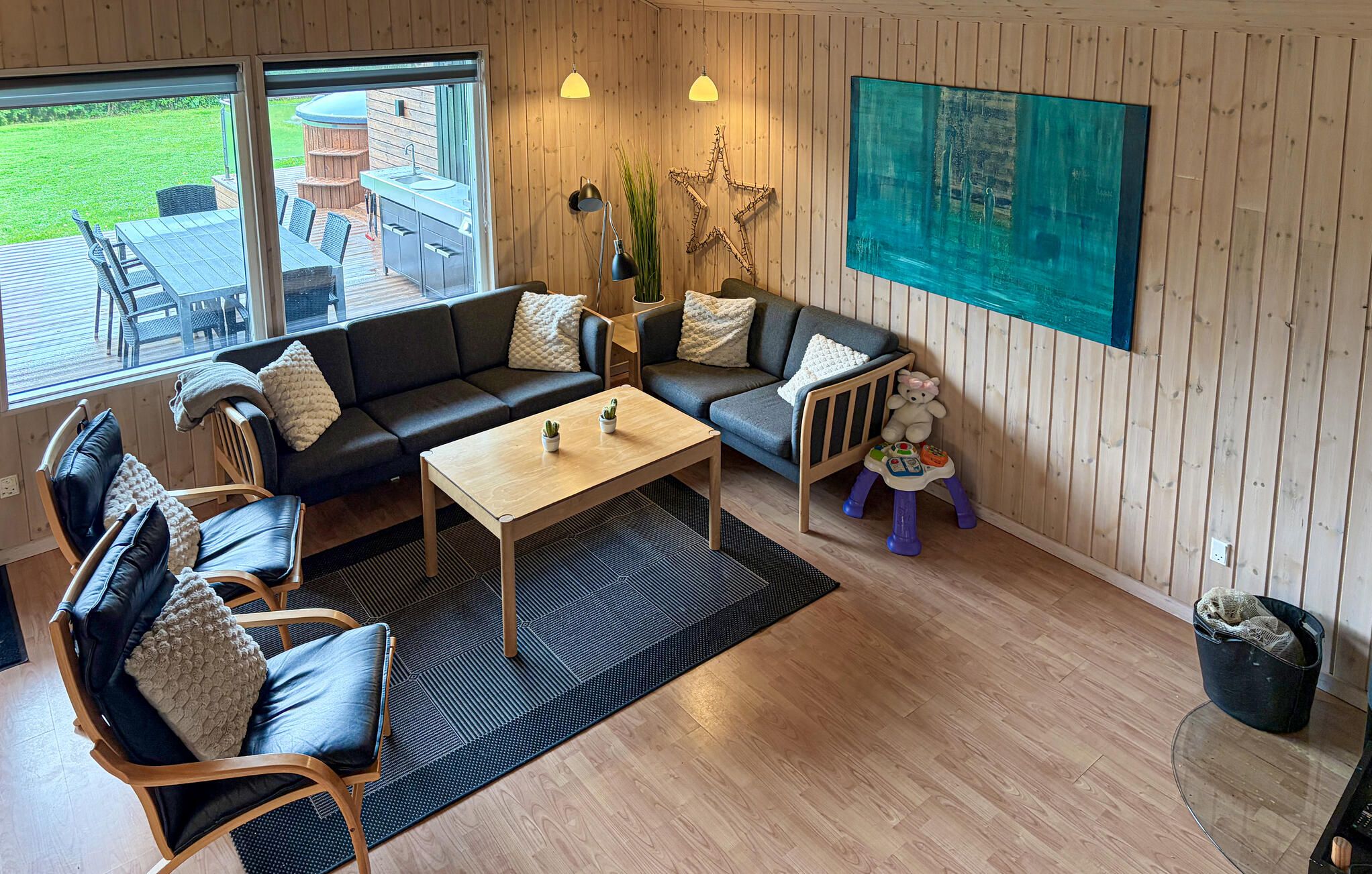 Un salon confortable avec un canapé, des fauteuils, une table basse et une table pour les jeux d’enfant.