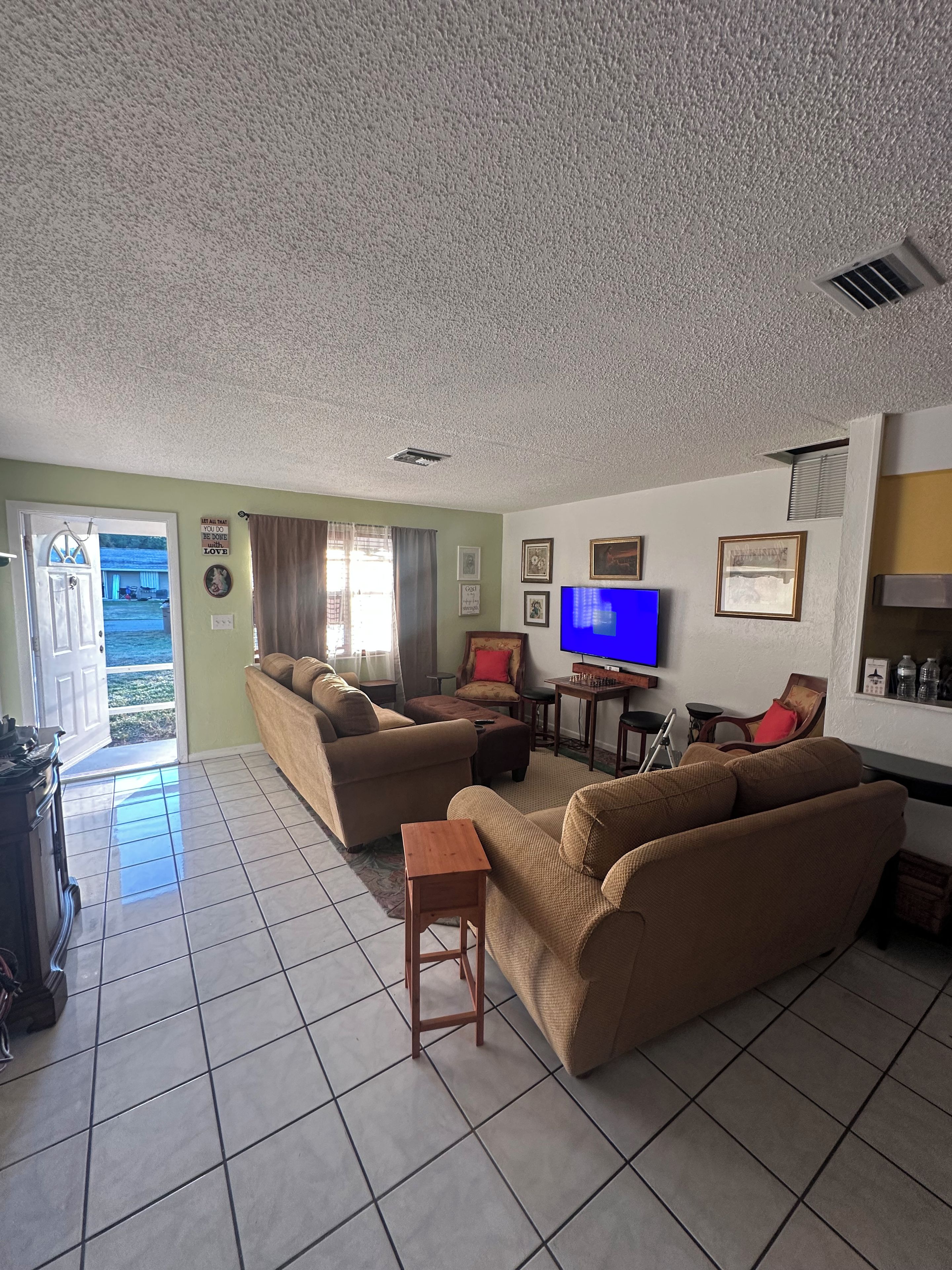 A living room with a sofa set, a television, and a small table.