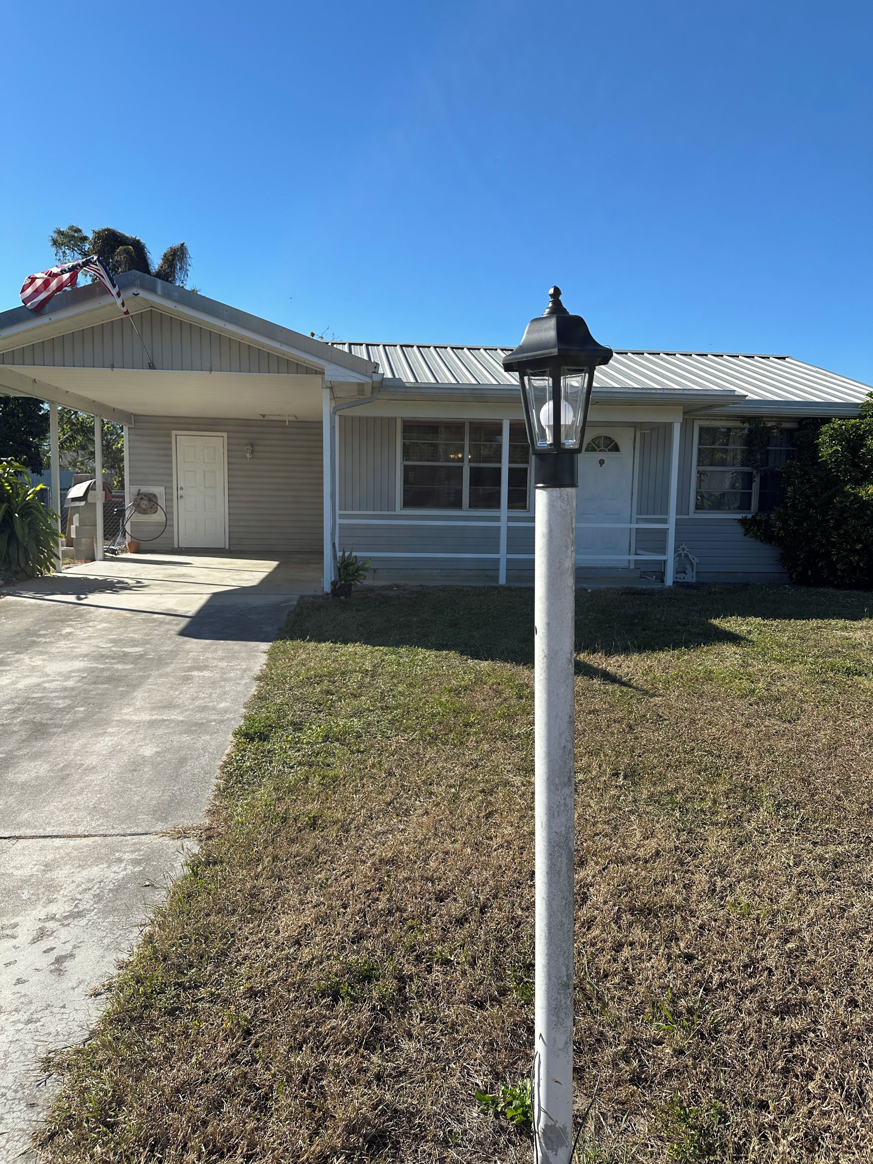 A residential house with a garage, a front porch, and a lawn.