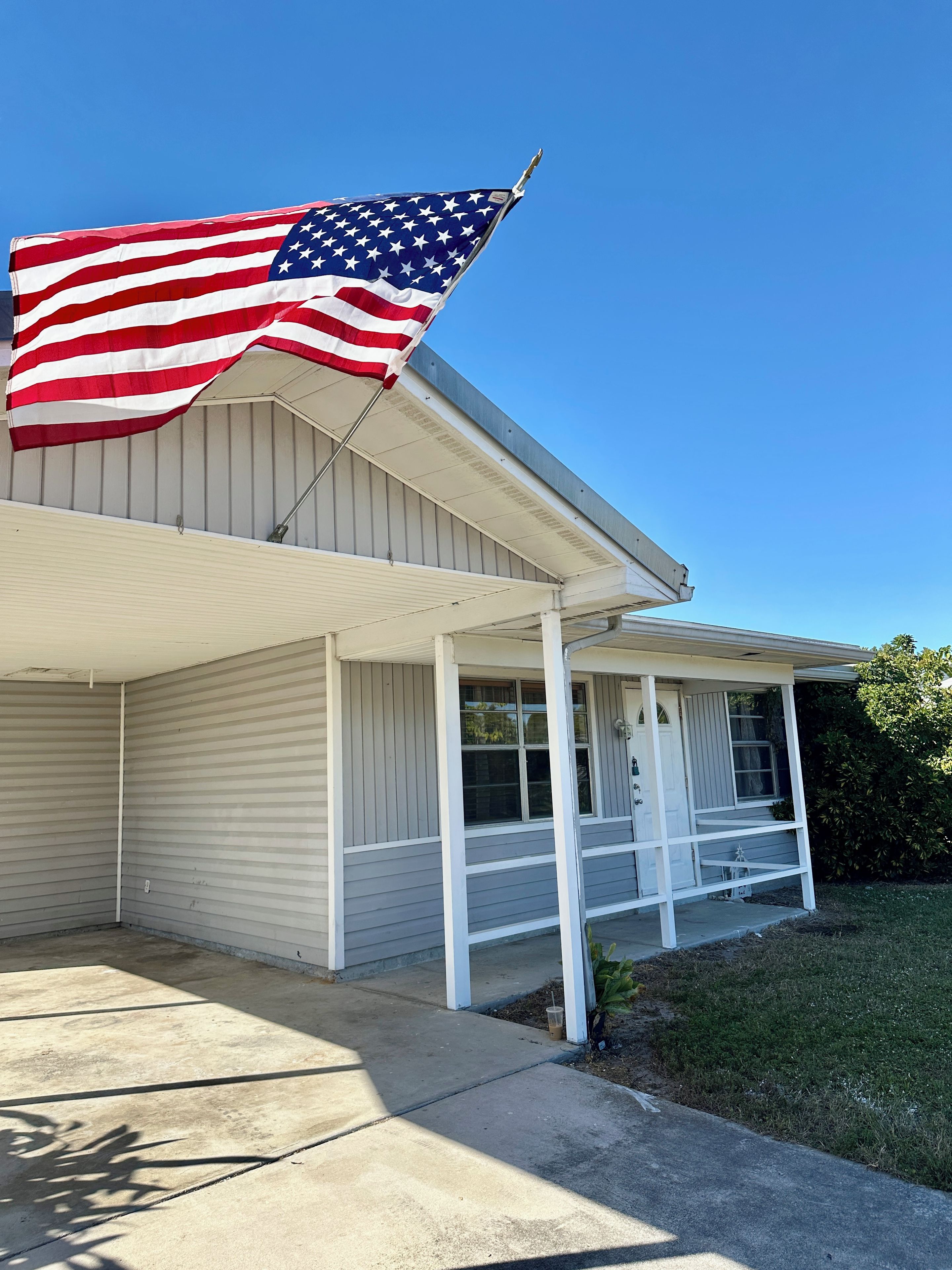 A house with a porch and an American flag.