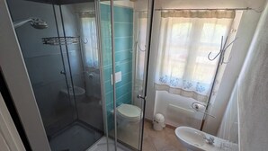 A bathroom with a glass-enclosed shower, a toilet, a sink, and a bathtub. - Apartment just a few meters from the beach (Quartu Sant'Elena)