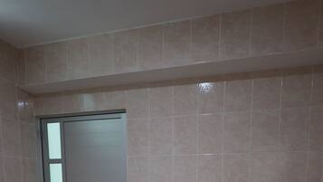 Quarto com cama, porta e corrimão branco.