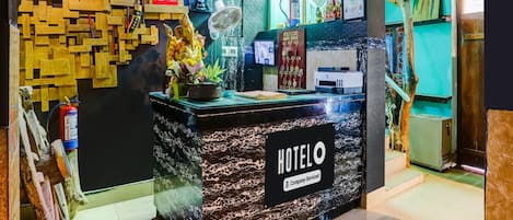 A hotel reception desk with a 'RECEPTION' sign, a 'HOTEL' sign, and a 'FUNFIRE GUEST HOUSE' sign.