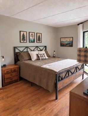 A bedroom with a bed, a nightstand, a lamp, and wall art. - VIEWS, Bears, Fireplace..Oh My!
Wonderful UPDATED 2B/2Ba Condo close to downtown (Gatlinburg)