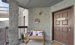 A wooden bench with cushions, a potted plant, a door with the number 310, and a textured wall. - VIEWS, Bears, Fireplace..Oh My!
Wonderful UPDATED 2B/2Ba Condo close to downtown (Gatlinburg)