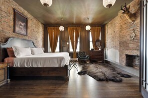 Una habitación con una cama, una silla, un tocador, una chimenea y una alfombra de piel grande.