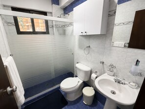 A bathroom with a glass-enclosed shower, two toilets, a sink, and a mirror. - Acogedor&Bello Apto en el Este + Planta Eléctrica (Barquisimeto)