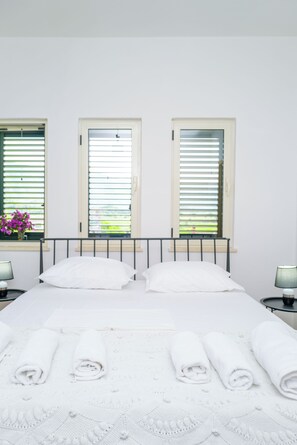 A bed with white linens, two bedside tables with lamps, and a window with blinds. - Twin Villa 2 Tragjas, Nature & River near Vlora (Tragjas)