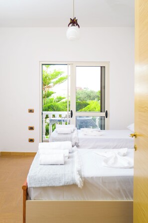 Une chambre à coucher avec un lit, une fenêtre et une vue sur la verdure.