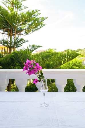 A table with a clear glass vase containing pink flowers, set against a white tablecloth. - Twin Villa 2 Tragjas, Nature & River near Vlora (Tragjas)