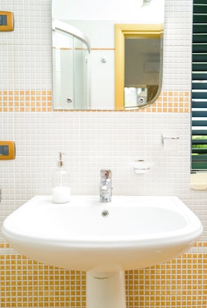 A bathroom with a white sink, a mirror, and a towel rack.